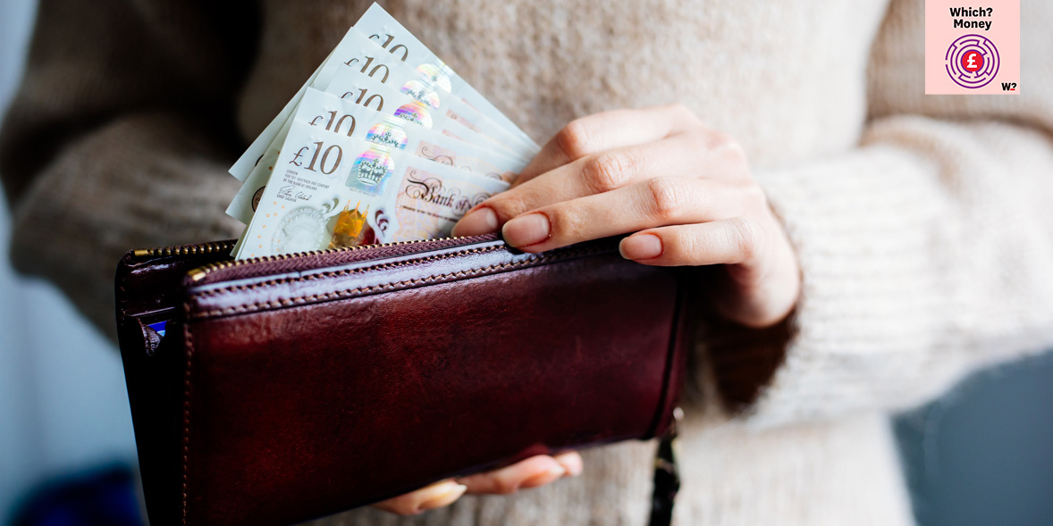 A woman holds ten pound notes she has removed from her purse