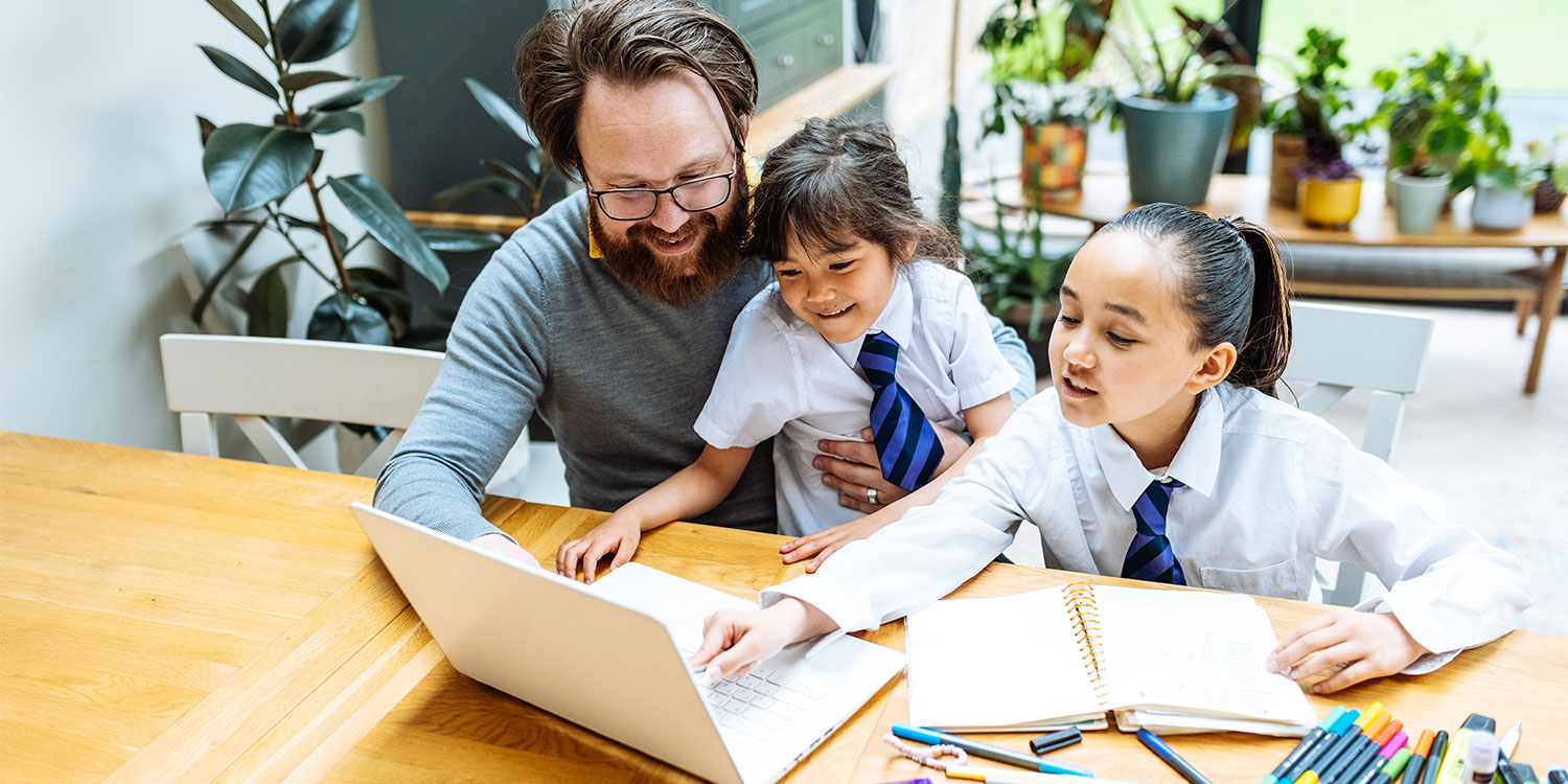 Man and children working on a computer