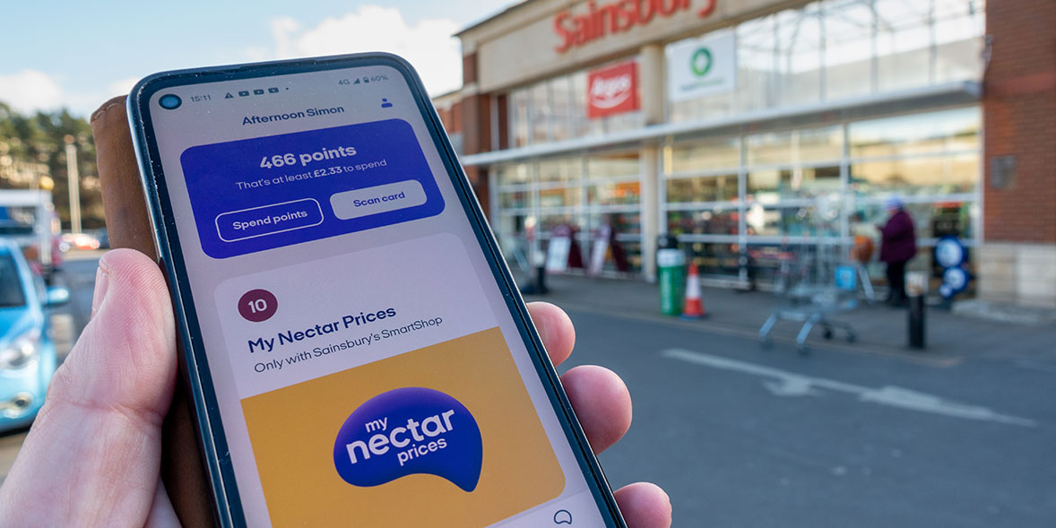 Nectar app on a shoppers' phone outside a Sainsbury's store